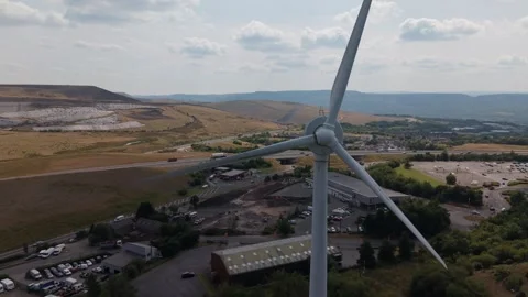 Drone Flying Backwards Past a Wind Turbine at Penygarnddu Wind Farm, Wales Vidéo 341144373