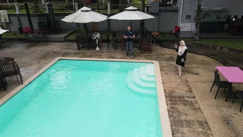 Drone flying Backwards from Swimming Pool and couple in Penang Stock Footage 149869757