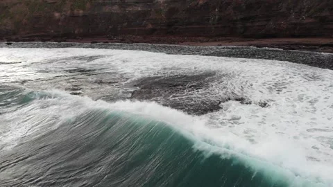 Drone flying from behind a wave and over as the wave crashes Stock Footage 135556588