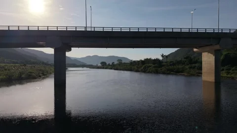 Drone Flying Beneath Bridge Over River In Mountain Valley Vietnam Stock Footage 337807689