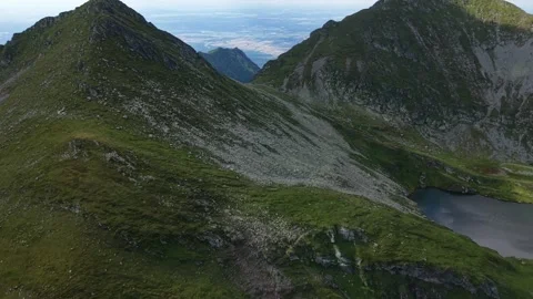 Drone flying between alpine peaks revealing distant valley in Romania Stock Footage 340824994