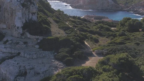 Drone flying between cliffs and raising up to turquoise water 스톡 동영상 100290979