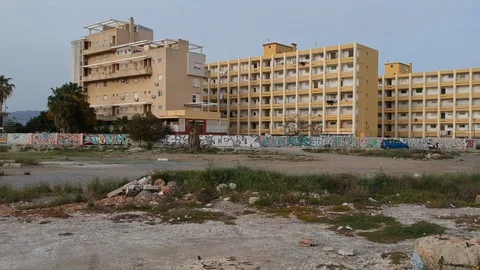 Drone flying between legs guy appears walking to poor buildings in Malaga Spain Stock Footage 130138356