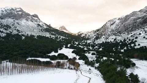 Drone flying between mountains with total snow cover during sunset Stock Footage 100292062