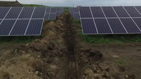 Drone is flying between the rows of solar panels, trenches with cables Stock Footage 160113192