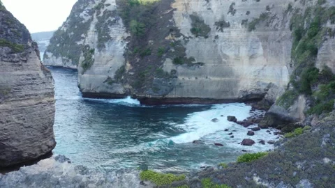 Drone flying between sea stacks to a hidden rocky cove, Nusa Penida Stock-Footage 339072073