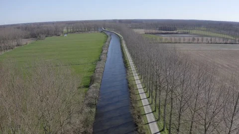 Drone flying up between trees while tilting down over river Stock Footage 126863562