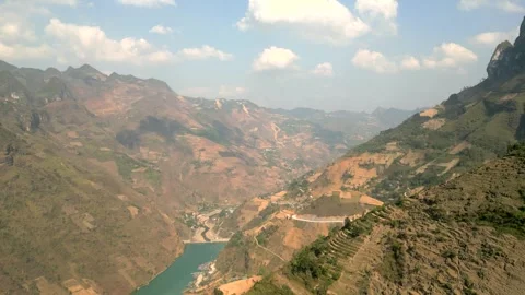 Drone flying in to a big valley with a smaragd colored lake in Ha Giang Vietnam Video stock 313798401