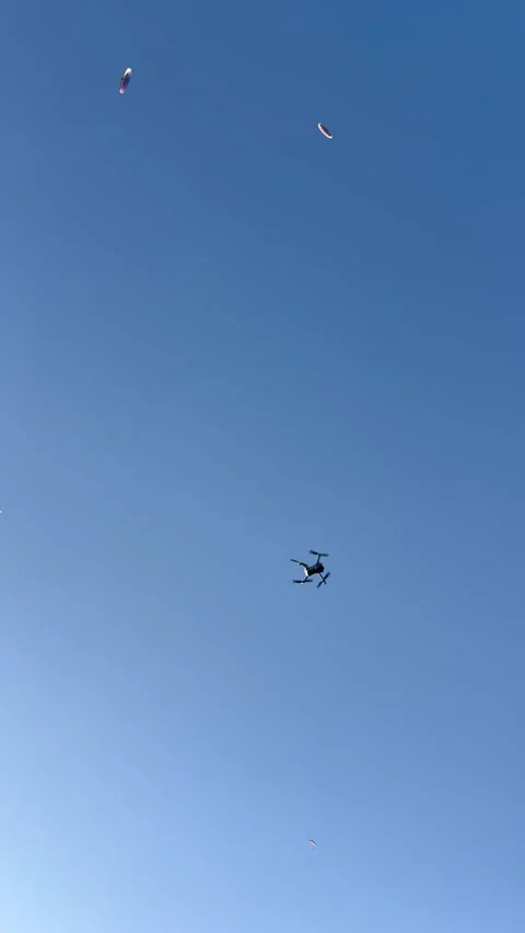 Drone flying in blue sky under paragliders by summer Stock Footage 337137973