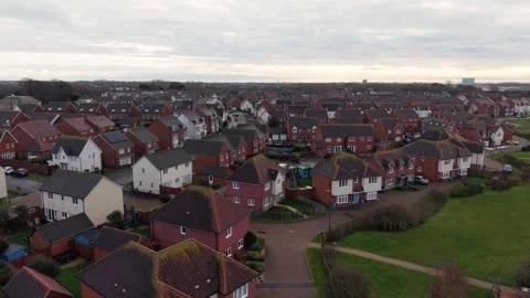 Drone flying in circular path around new build housing estate - Aerial drone Stock Footage 328125663