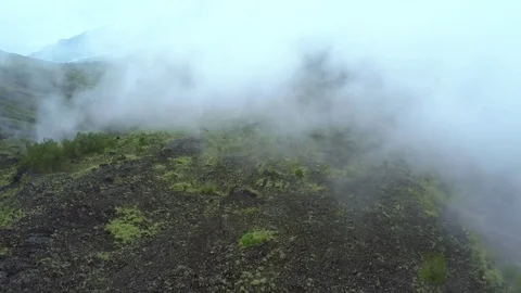 Drone flying in the clouds above the volcano.Incredible shot Stockbeeldmateriaal 72560634