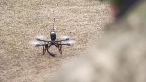 Drone flying at distance over dirt terrain with payload Stock Footage 334695931