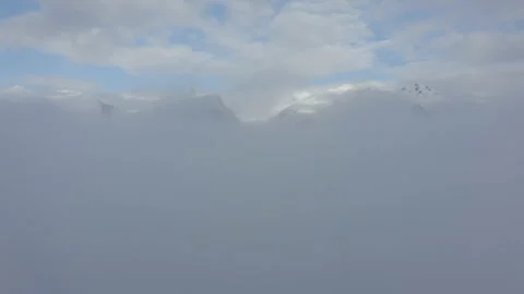 Drone flying down and up through the clouds to discover the mountian ridge o Stock Footage 145699720