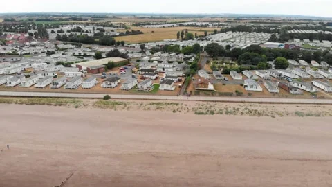 Drone flying down beach overlooking caravan site in the united kingdom Stock Footage 141462344