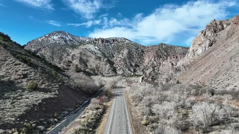 Drone flying down highway inside a canyon in the rocky mountains Stock Footage 229807426
