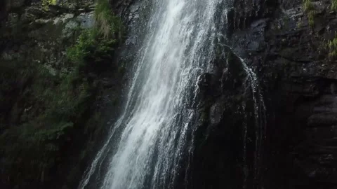 Drone flying down a strong stream of a waterfall in the mountains 4k Stock Footage 137921227