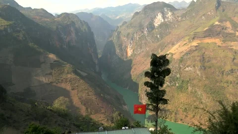 Drone flying into an enormous valley with a emerald lake in between mountains Stock Footage 313798443