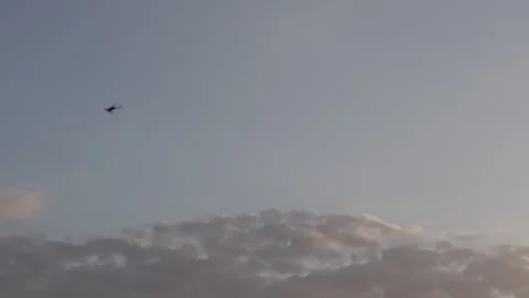 A drone flying in the evening sky above a landscape with clouds during sunset Stock Footage 290373571