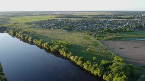 The drone is flying flying across the river and a village  Stock-Footage 155884735