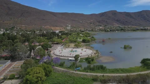 Drone flying forward above Jocotepec pier with trees, park and lakeside views Stock Footage 322546891