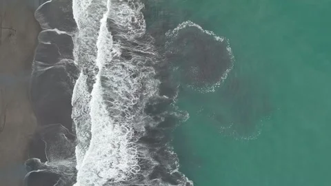 Drone flying forward above Pacific Ocean waves and black sand tropical beach Video stock 338312127
