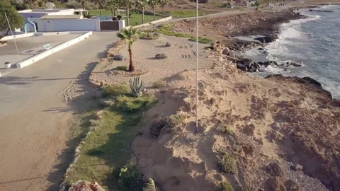 Drone flying forward above a rocky beach to Greek flag. Crete, Greece Stock Footage 135057230