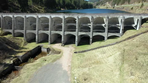 Drone flying forward and rising over dam revealing lake, cinematic aerial shot Video stock 333071217