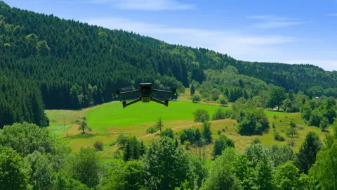 Drone flying forward from the foreground towards a lush green forest Stock Footage 315742707