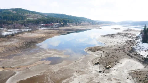 Drone flying forward over dried lake with low water level and exposed shoreline Video stock 332048244