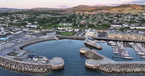 Drone flying forward over entrance to Greystones Marina, breakwater walls sho Stock Footage 340323489