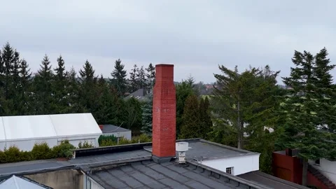 Drone Flying Forward Over Flat Roof Towards Red Brick Chimney On Cloudy Day Stock Footage 330750439