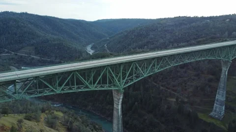 Drone flying forward over Foresthill Bridge in a scenic mountain valley Stock Footage 303702597