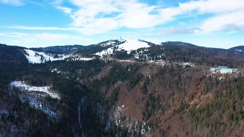 Drone flying forward over mountain valley with forest and snow patches Stock-Footage 332047464