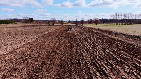 Drone Flying Forward Over Plowed Farmland With Tractor Working in Rural Latvia 库存影片 348782307