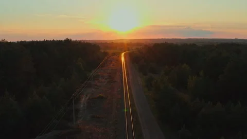 Drone flying forward over railway track while beautiful sunset. Suburban rail Stock Footage 194402336
