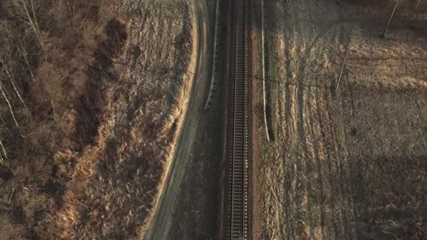 Drone flying forward over railway track while beautiful sunset. Suburban railway Stock Footage 241012973