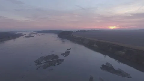 Drone Flying Forward Over River Ascending To Sunrise Raw Stock Footage 78870647