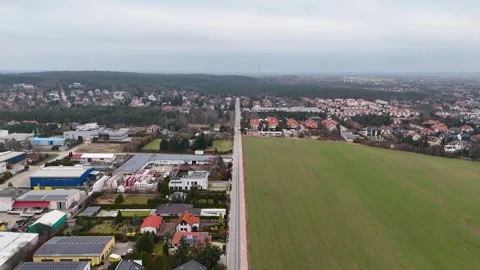 Drone Flying Forward Over Suburban Road With Trucks Between Town And Field Stock Footage 330750602