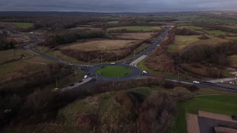 Drone flying forward over UK roundabout with traffic Stock Footage 326975347