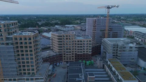 Drone flying forward over urban construction site at dusk 動画素材 345255559