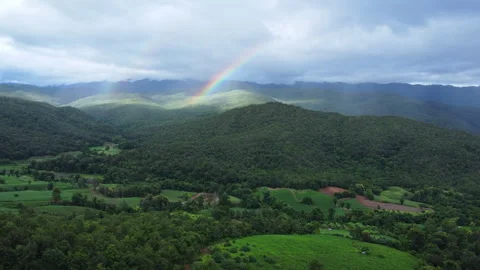Drone flying forward towards scenic mountain range with rainbow in sky Stock Footage 341368584
