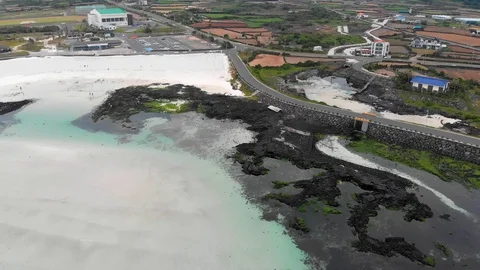 Drone flying forwards over beach and fields while camera pans up Stock Footage 91092358