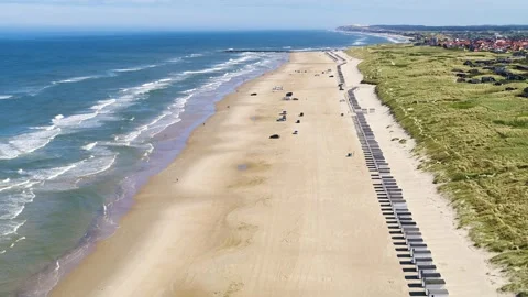 Drone flying forwards over beach with long row of beach huts Stock Footage 298649758