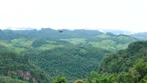 Drone is flying on green filed with background of mountain landscape view Stock Footage 133107960