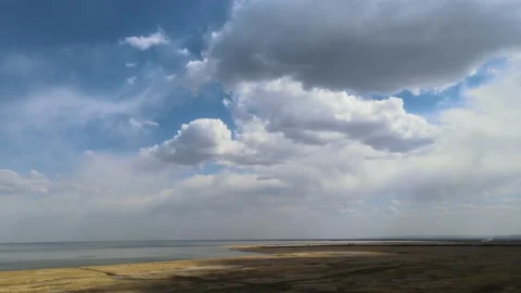 Drone flying high above a dry looking marsh next to a large lake  Stock Footage 154174480