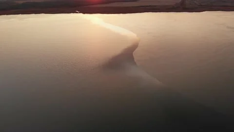 Drone flying high above a partially frozen lake at sunset. Stock Footage 142809037