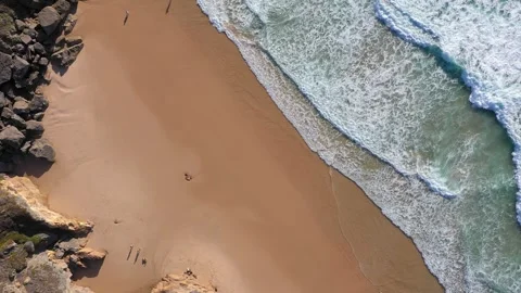Drone flying high above the shore with blue waves of amazing beauty, tourists Stock Footage 255408804