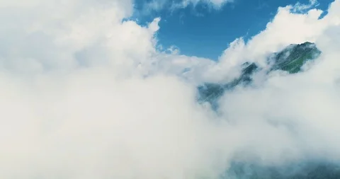 The drone is flying high in the blue sky through the fluffy clouds over Stock Footage 127097446