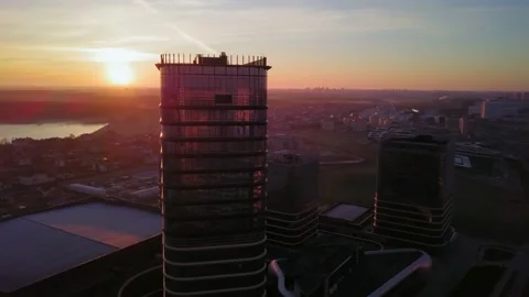 Drone flying left around high rise city tower in early red sunrise Stock Footage 134905025