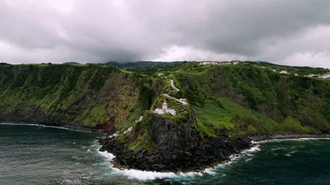 Drone flying to Lighthouse Farol Ponta do Arnel from ocean side Stock Footage 224517122